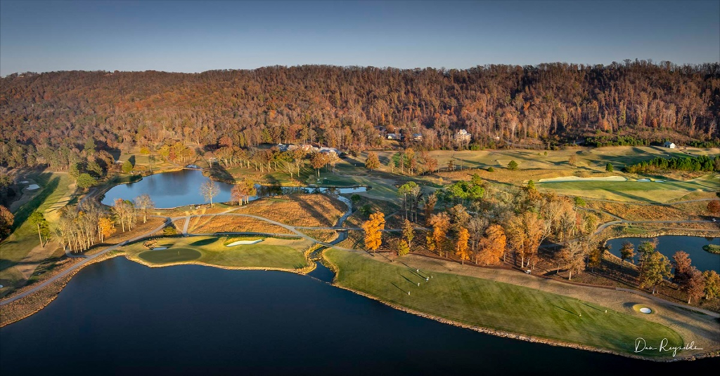 Aerial view of The Honors Course in Ooltewah, Tennessee, featuring championship golf greens, scenic lakes, and wooded hills during autumn.